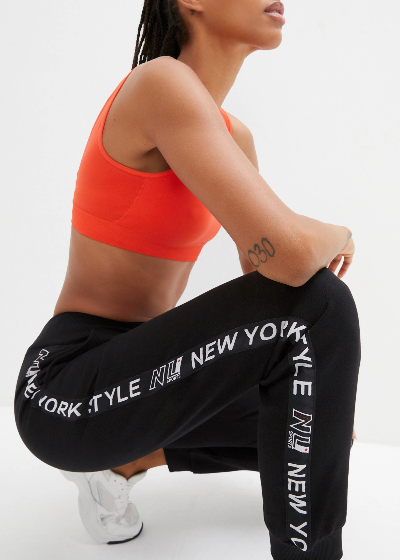 Spodnie dresowe ze ściągaczami i napisem z boku nogawek • czarny • sklep bonprix