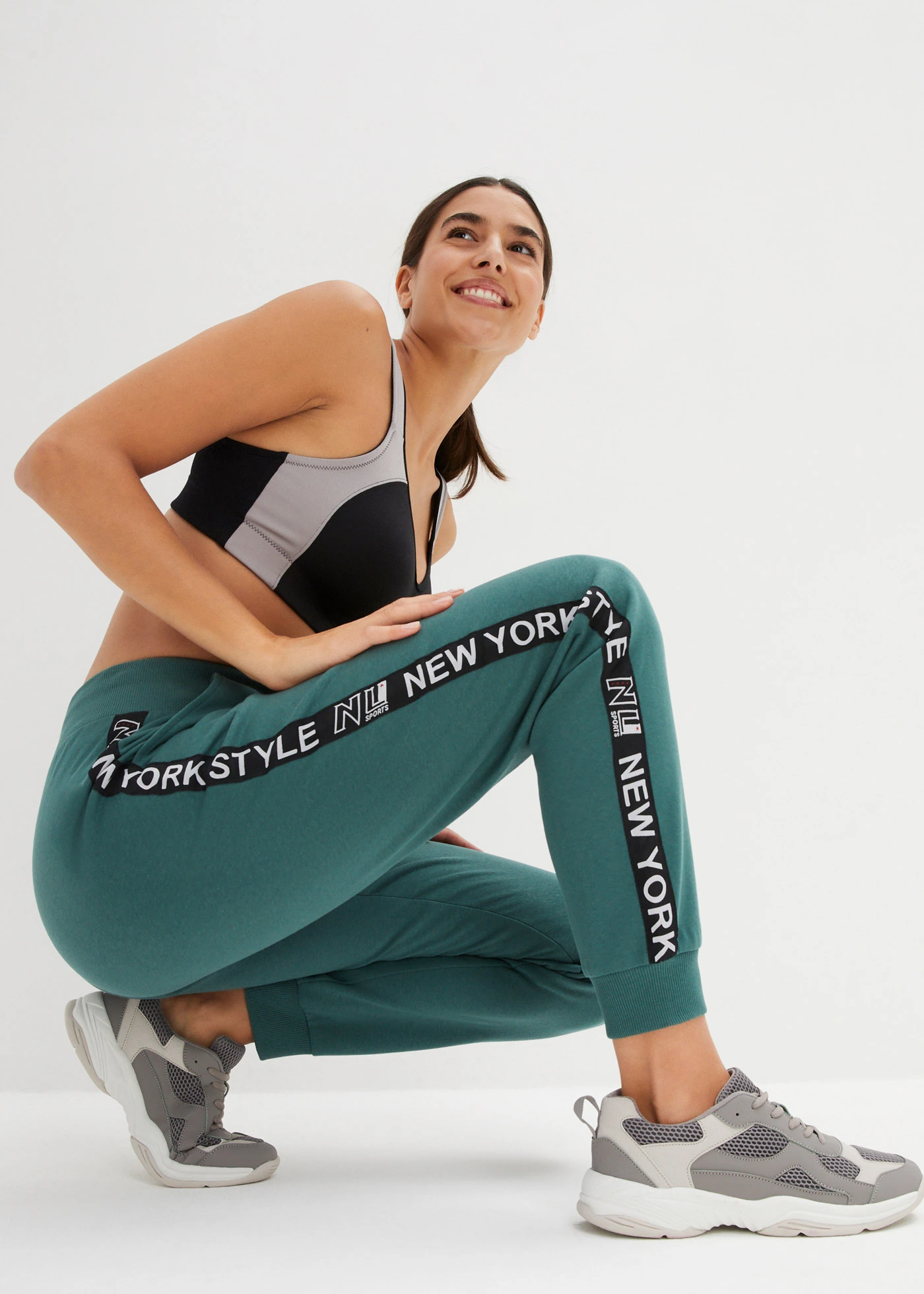 Spodnie dresowe ze ściągaczami i napisem z boku nogawek • zielony matowy z nadrukiem • sklep bonprix