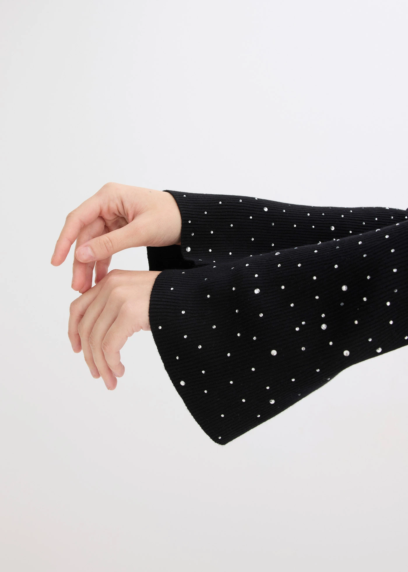 Pulover din tricotaj fin cu mâneci tip trompetă cu ștrasuri • negru • magazin bonprix