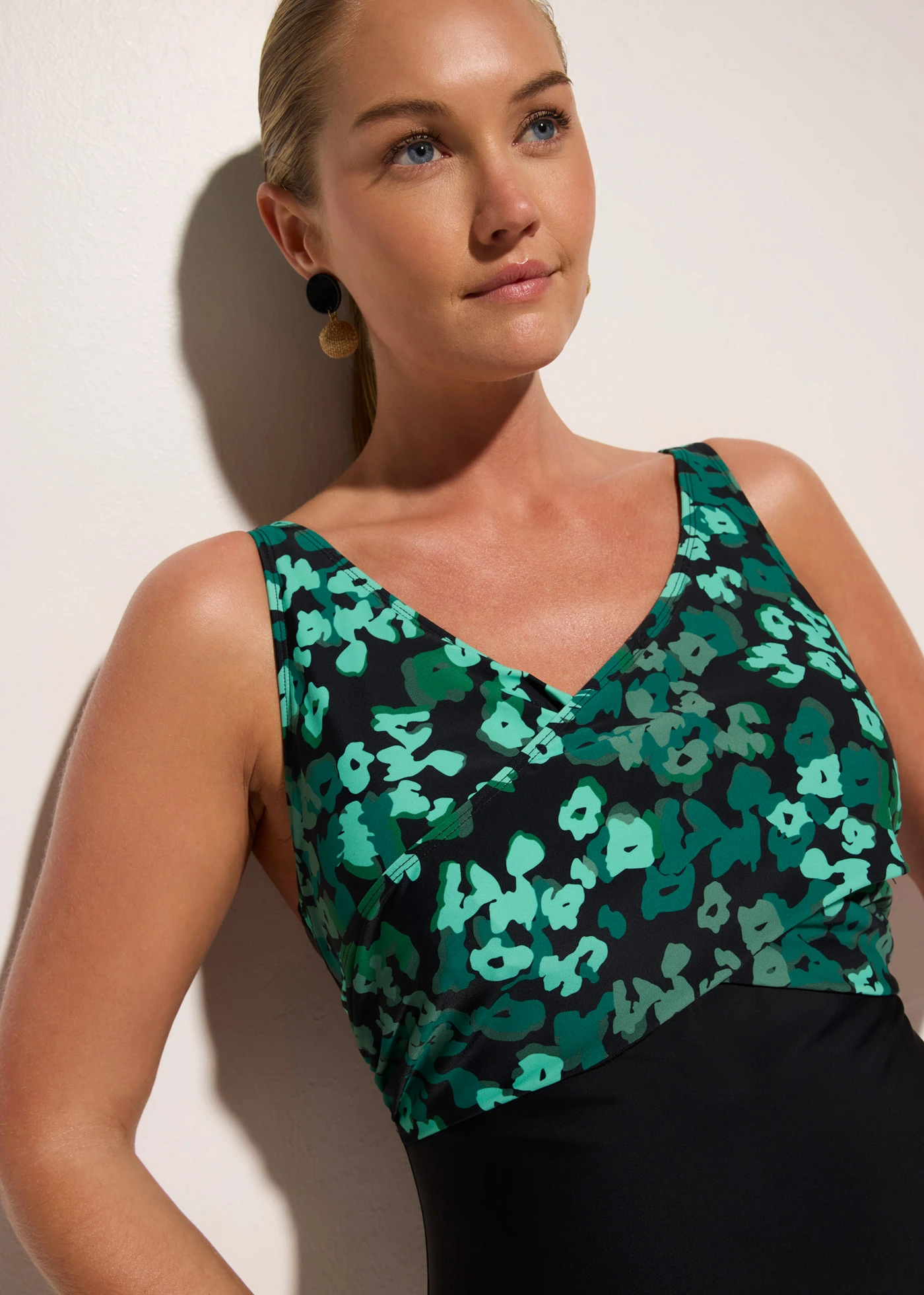 Stahovací jednodílné plavky se zavinovacím vzhledem, střední tvarující efekt • černo-zelená s květy • bonprix obchod