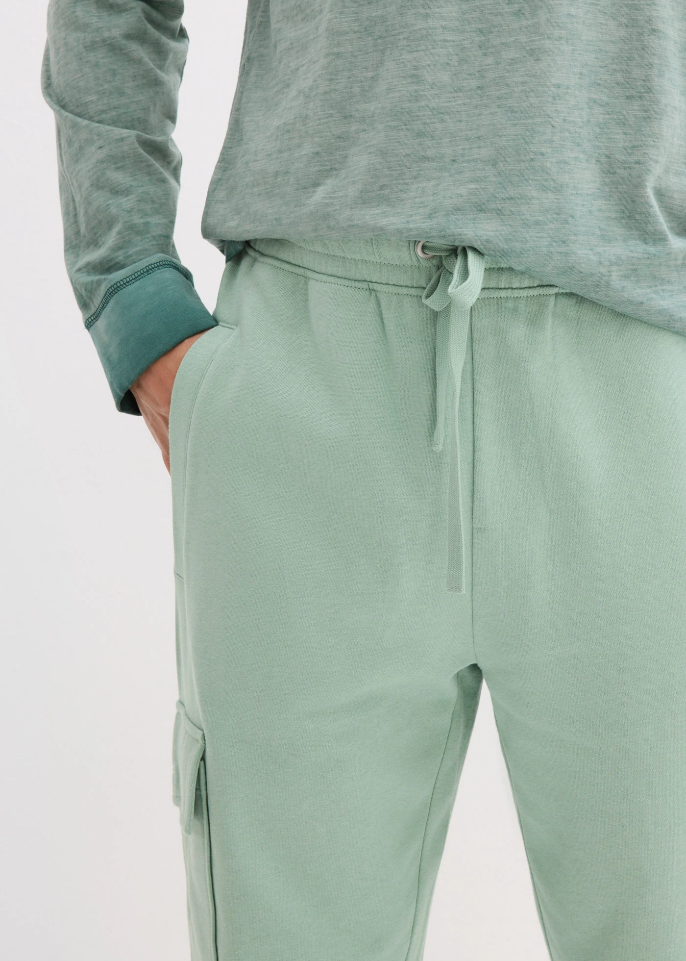 Spodnie sportowe z kieszeniami cargo, loose fit • zielony pastelowy • sklep bonprix