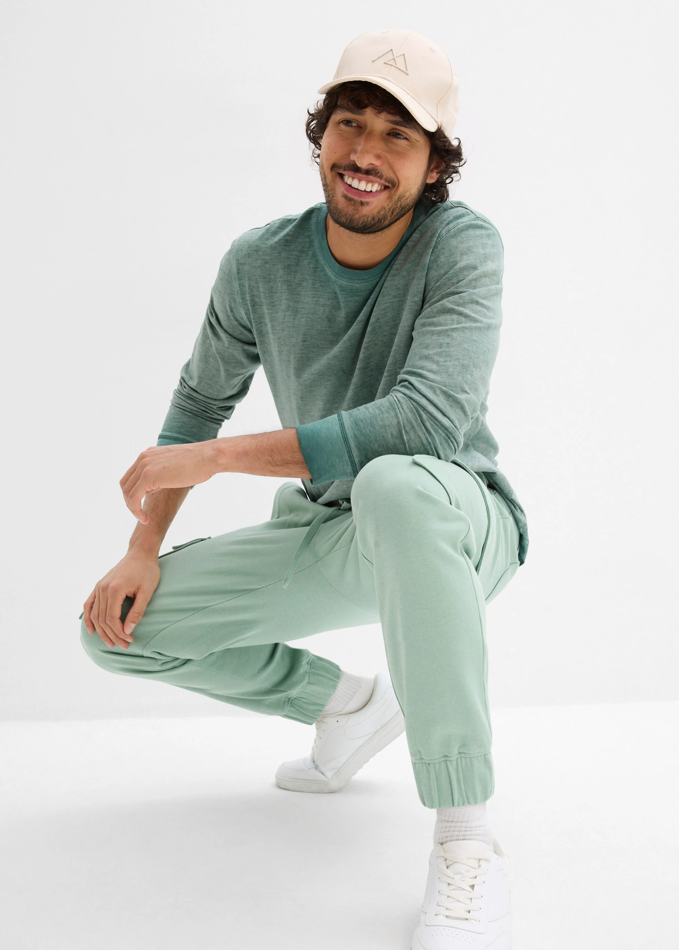 Spodnie sportowe z kieszeniami cargo, loose fit • zielony pastelowy • sklep bonprix